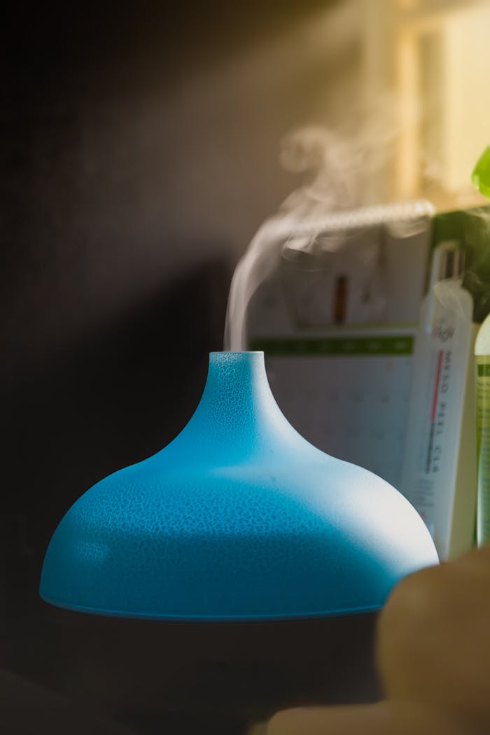 Close-up of a blue humidifier releasing vapor, creating a serene indoor atmosphere.